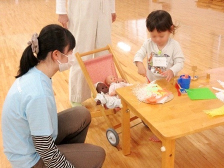 子供がピザを赤ちゃんに差し出している様子